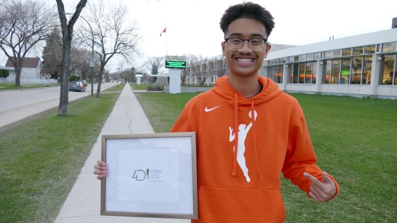 A teenage boy is pictured smiling toward the camera/