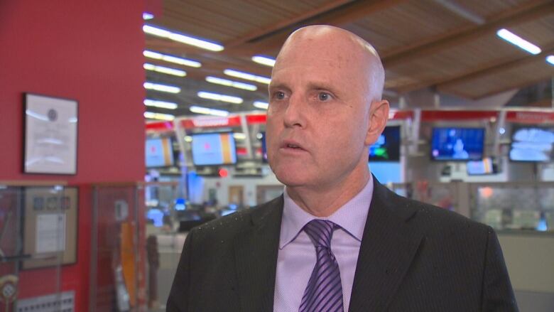 A bald white man speaks to a camera in a newsroom.