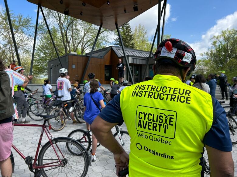 A Vlo-Qubec person on duty, surrounded by other cyclists. 