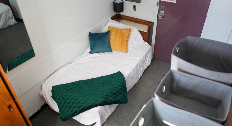 A simple university residence room with a single bed