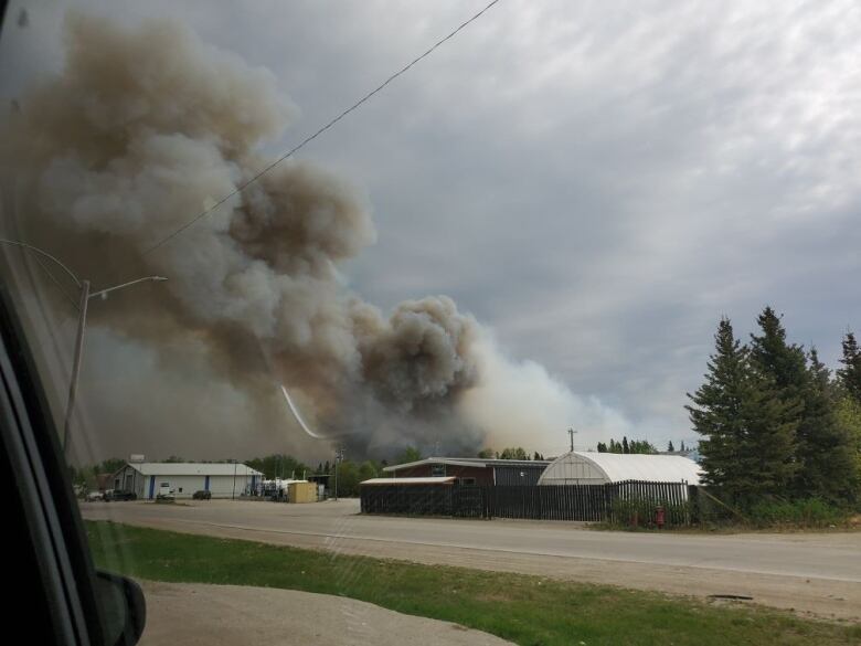 Smoke billows above buildings. 