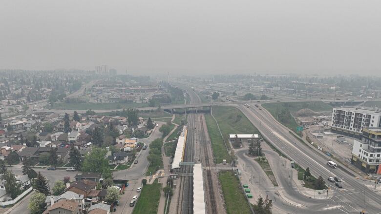 A bird's-eye view of gray smoke over a highway in Calgary. 