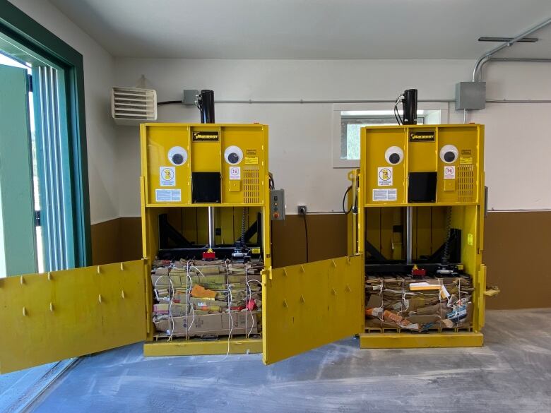 Two brand new yellow balers sitting full at the brand new solid waste diversion facility in Dawson City.