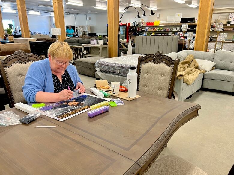 Woman at table with crafts.