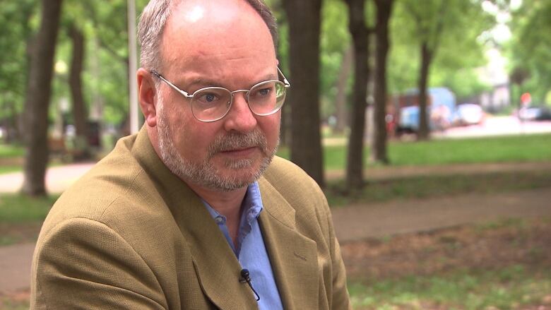 A man sits in a park. 