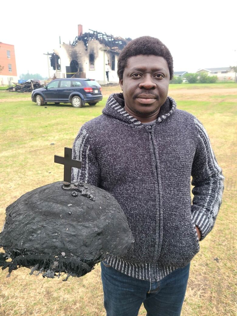 A man holds a singed tabernacle.