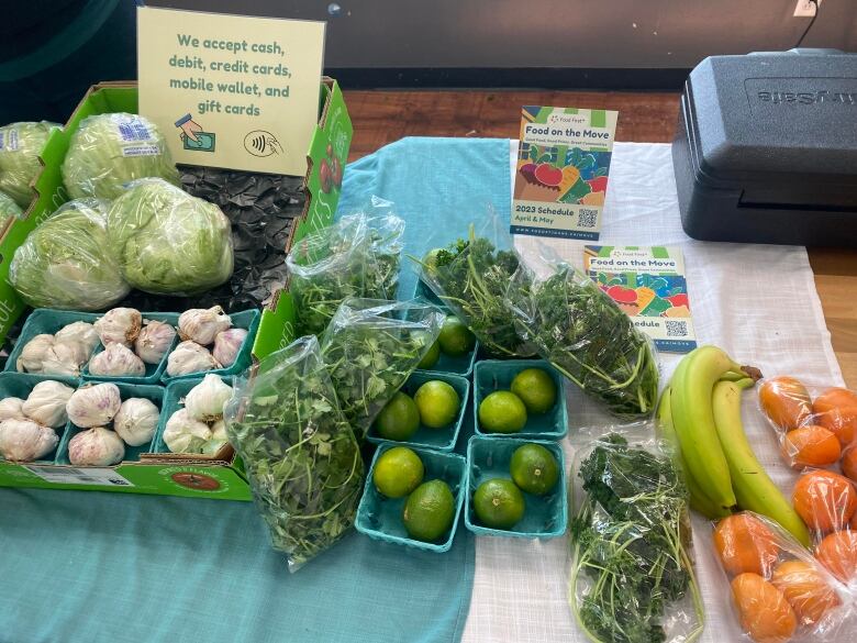 Various produce  including limes, garlic, bananas and oranges  sit on a table.