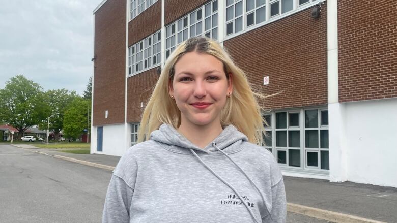 A girl in front of a school building.