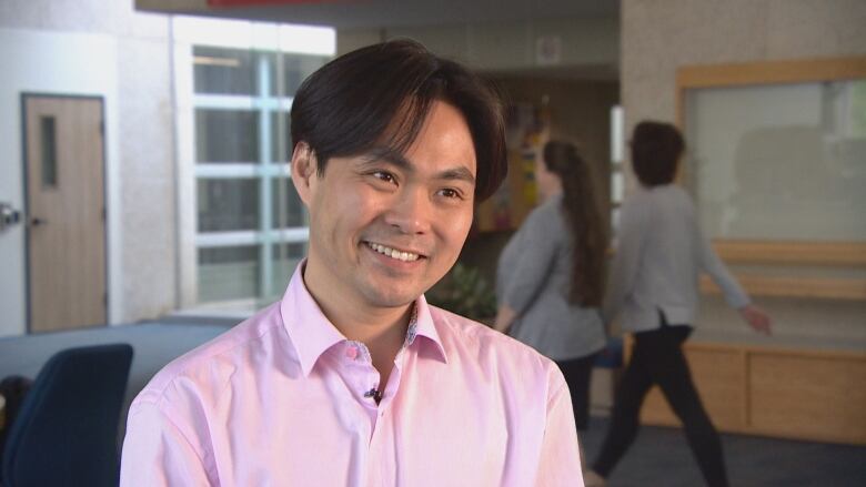 Filmmaker Weiye Su is smiling and has short black hair and a pink button-up shirt on.