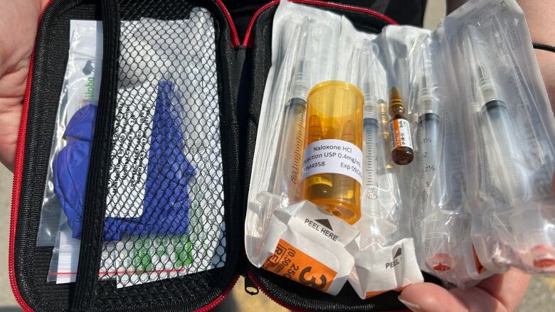 A medical kit filled with vials and needles is show.