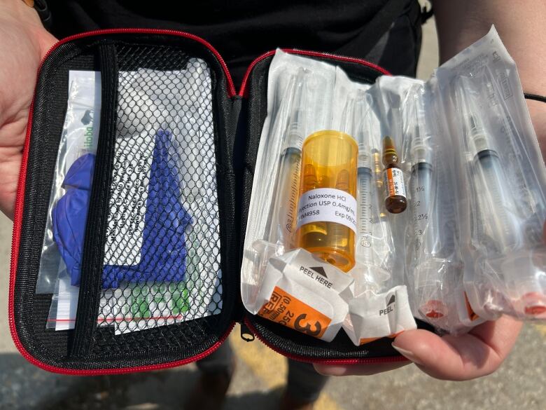 A medical kit filled with vials and needles is show.