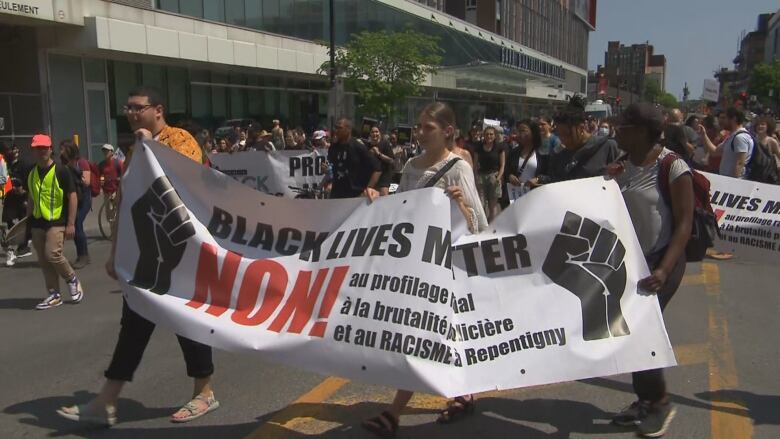 People hold up a sign in a march.