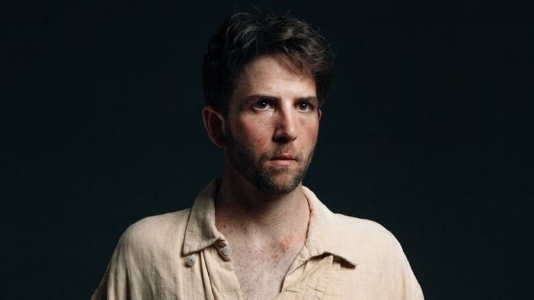 Head shot of Owen Pallett against a dark background.