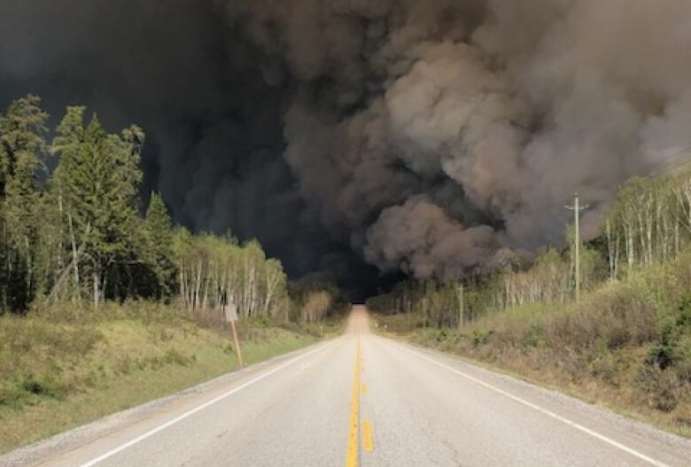 Black smoke from a nearby forest fire fills a northern highway in Ontario.