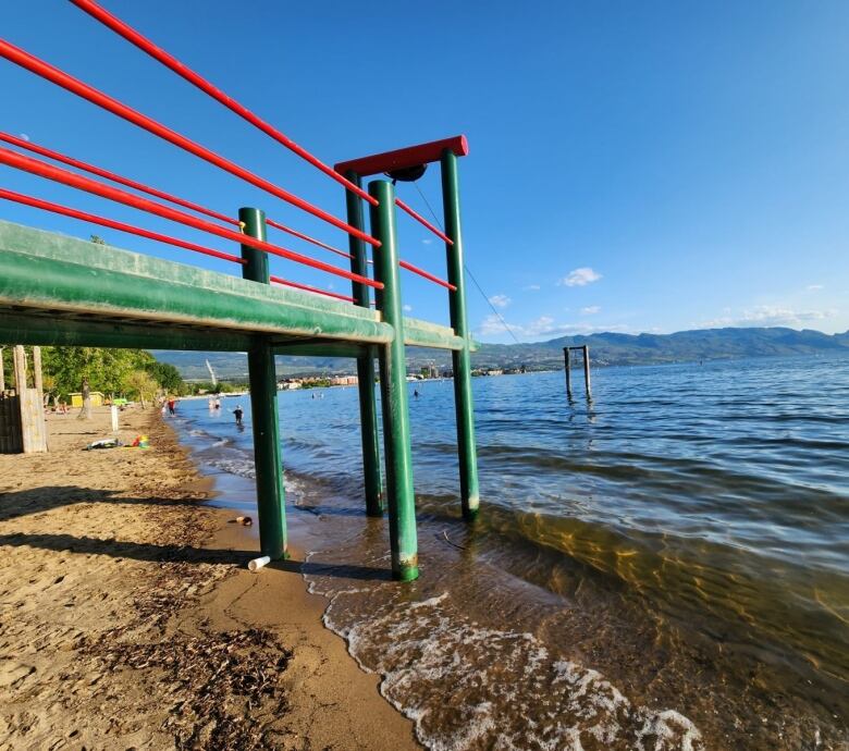 A zipline suspended from a tall platform that extends into a large lake.