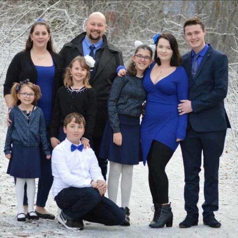 A large family, with multiple children and people posing for a picture.