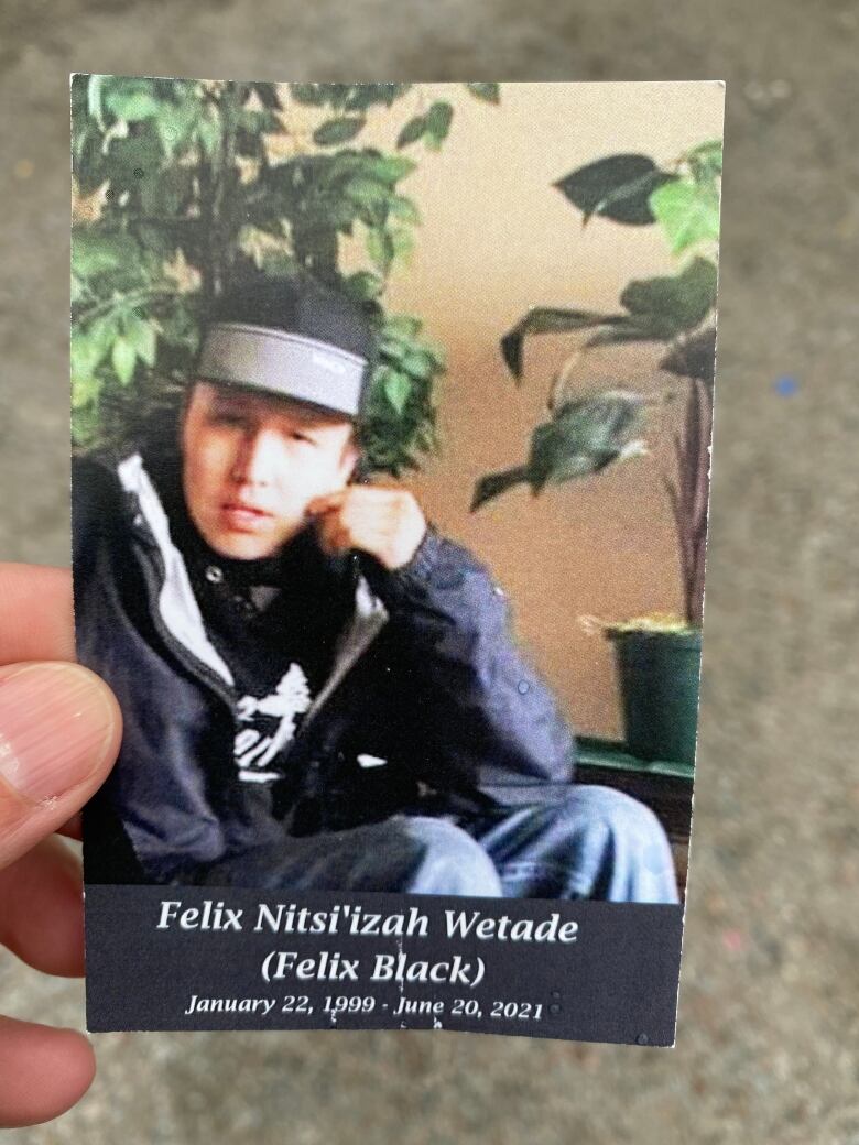 Hand holding a card with photo of young man.