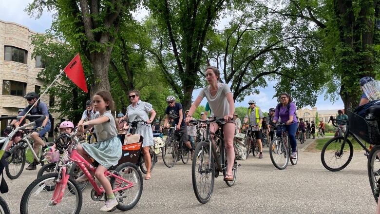 A group of cyclists ride in spring. 