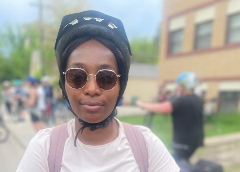 A young woman in a white first with a helmet on. 