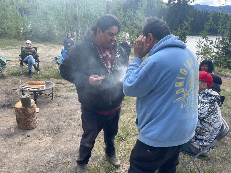 Two men performing a ceremony with smoke.