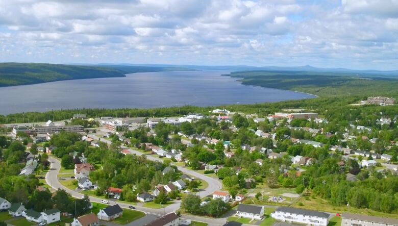 A top-down view of a town with a body of water in the background. 