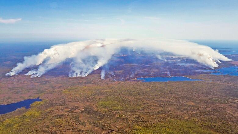 An aerial shot shows smoke from several points on land rising into the air.