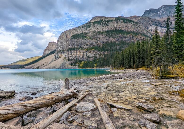 The view from a beach looking at a lake in the mountains.