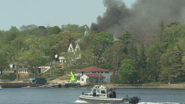 Dark smoke coming out of a building on fire.