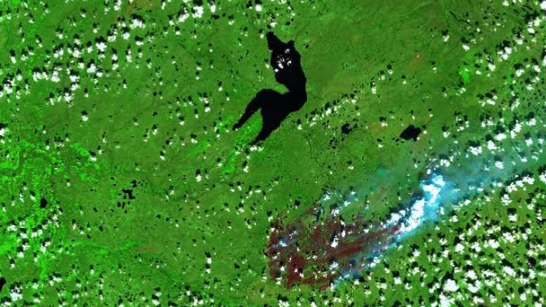 A satellite image shows Sambaa K'e and a nearby fire.