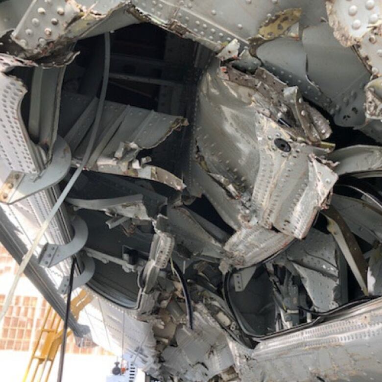 A photo of a damaged aircraft, with metal torn and ripped.