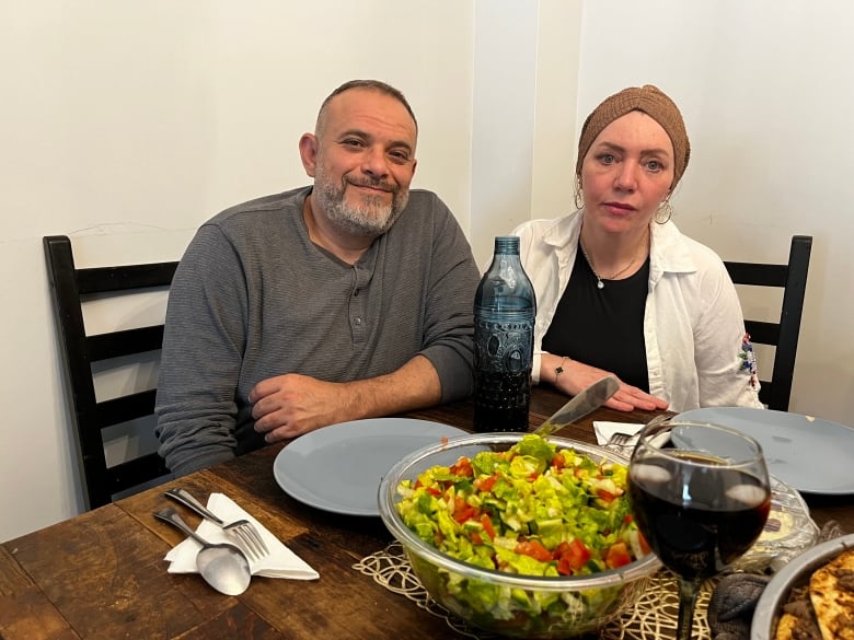 A husband and wife at a dinner table. 