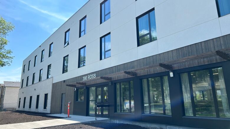 The front of a brand new building is seen on a sunny summer day.