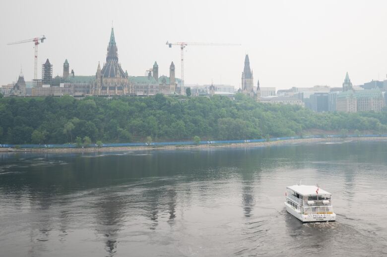 A boat on a smoky river near a legislature.