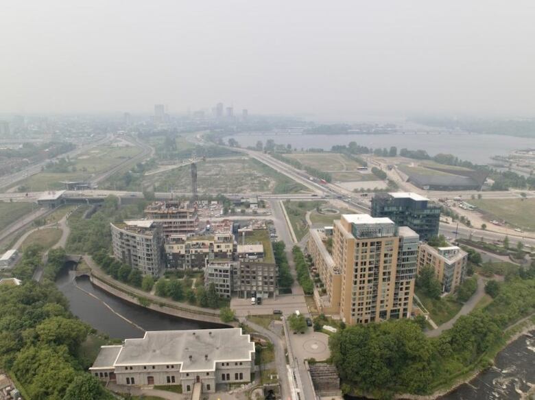 A view of some highrises on the edge of a city's downtown and wildfire smoke obscuring the view beyond it.