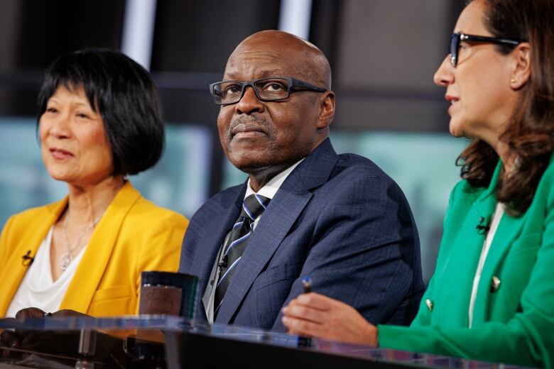 Toronto mayoral candidate Mark Saunders takes part in a televised debate hosted by Marivel Taruc in the CBC Broadcast Centre in Toronto, on June 6, 2023. On his left is candidate Olivia Chow, on his right is Ana Bailo.