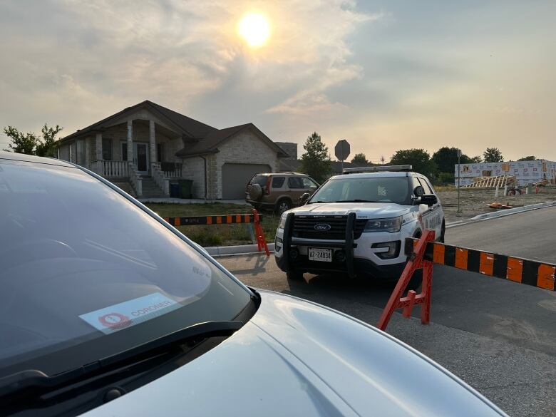 A police cruiser in the background while a vehicle with a dashboard placard that says 