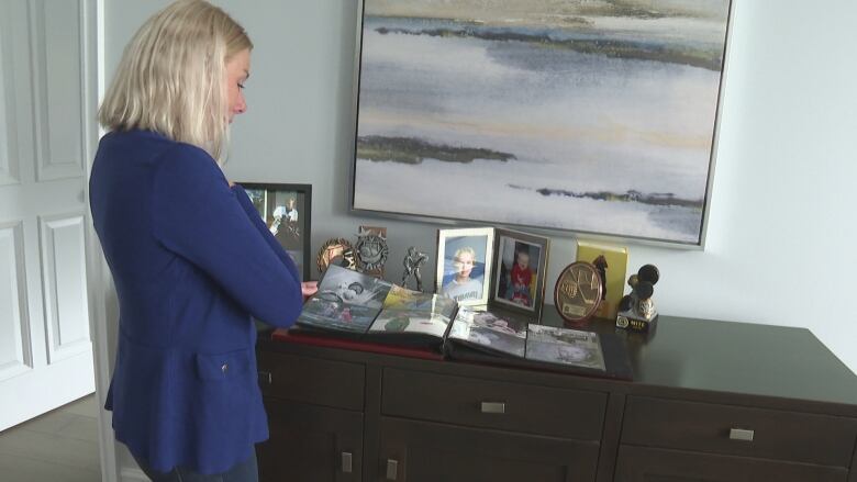 Sarah Budd looks at photos of her late son, Aidan Tate. The Peterborough, Ontario mother is warning parents about the dangers of illegal online sales of benzodiazepines like Bromazolam.