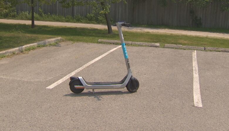 An electric scooter left in between a parking spot