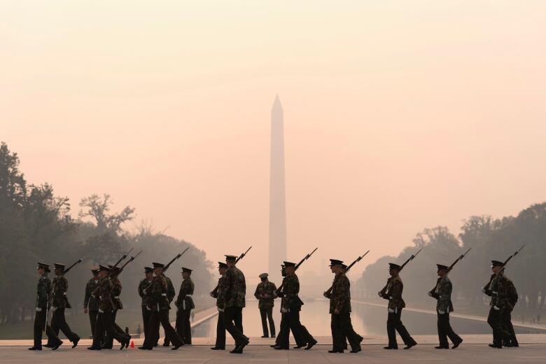 Silhouette in soldiers front of minument 