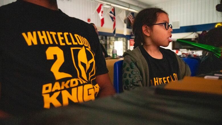 A young man holds a noise maker while cheering on the Las Vegas Golden Knights.