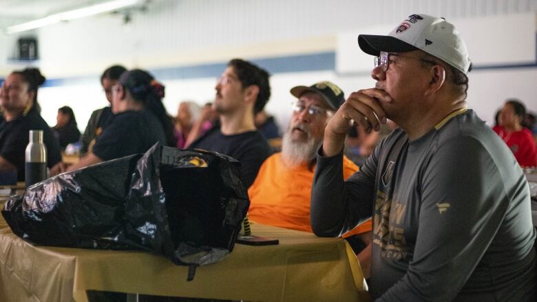 A man pensiveley watches a hockey game.