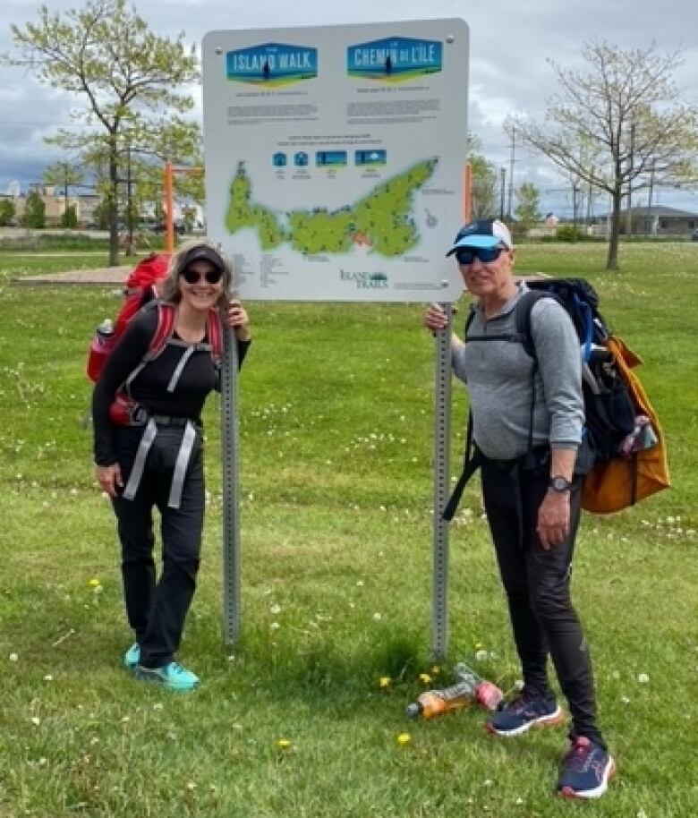 Carrie Lee and Martin Denonville stand next to the PEI trail sign.