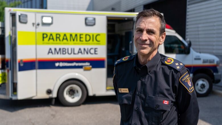 The chief of a city's paramedic service poses for a photo outside in summer.