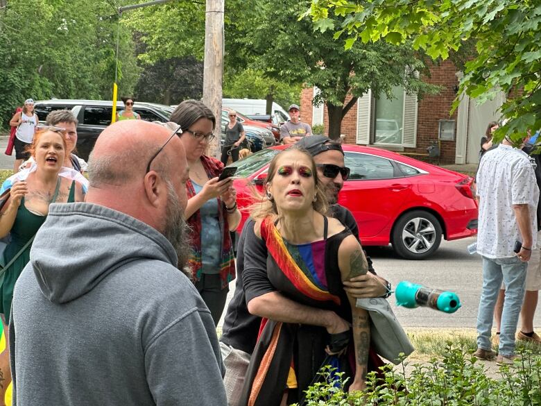 An activist is held back while trying to approach a protester.