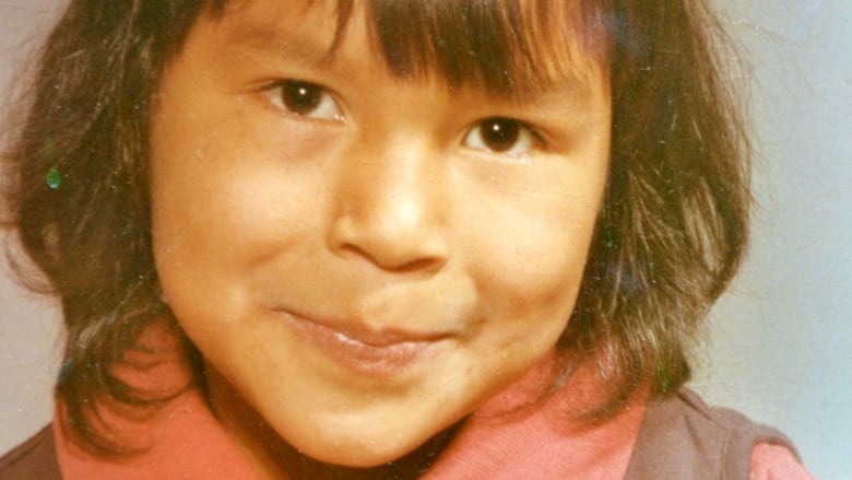 Carol Rose GoldenEagle at the age of 5 wearing a collared shirt with a bow on her hair.