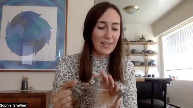 Screenshot of a Zoom call. Sophie Jarvis holds a speckles teapot that perfectly matches her speckled shirt.