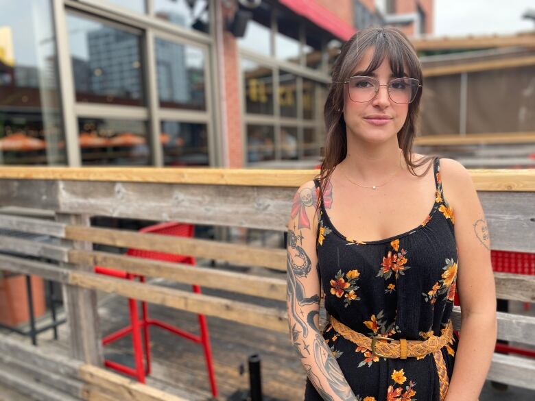 A woman stands in front of a patio.