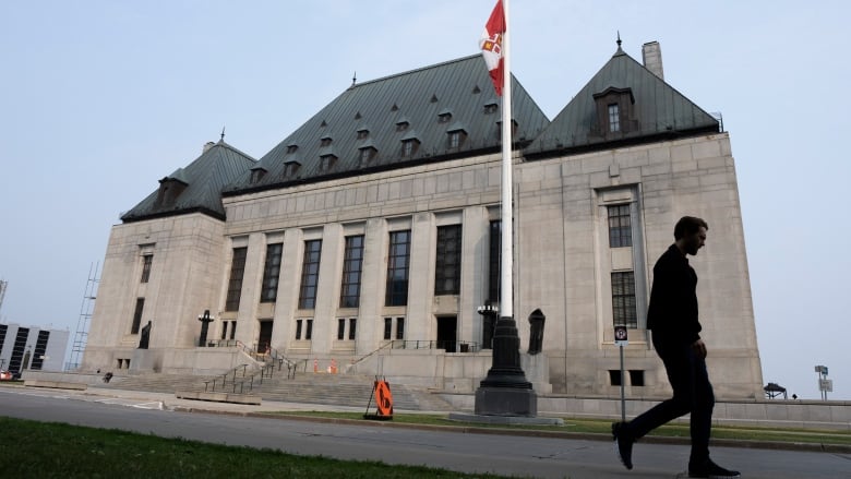 A man walks by the Supreme Court of Canada building in Ottawa.