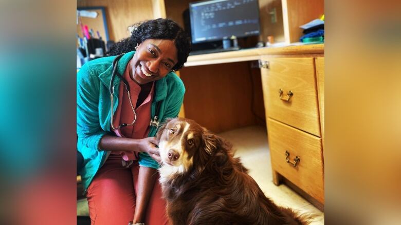 A woman is pictured with a dog inside an office.