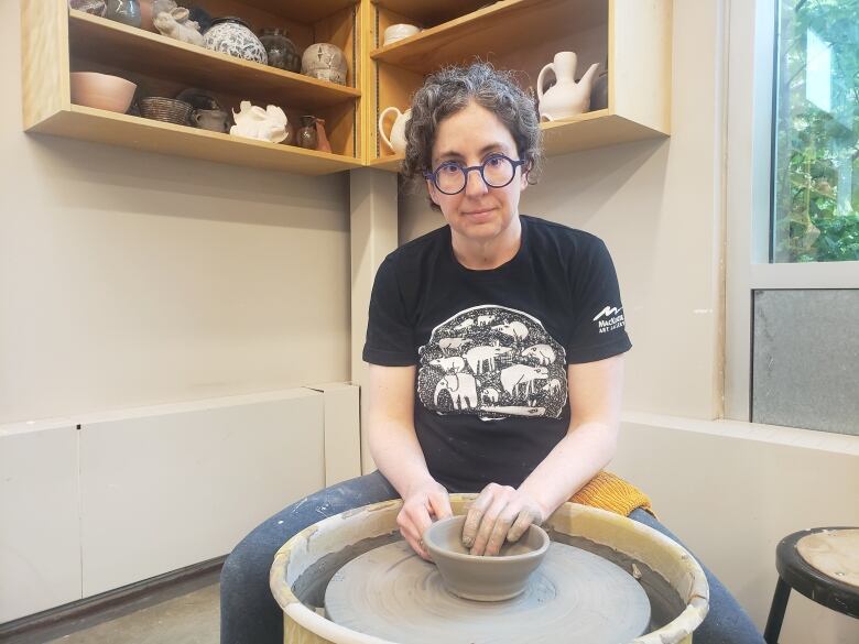 Amy Snider throws pottery in a studio at the University of Regina.